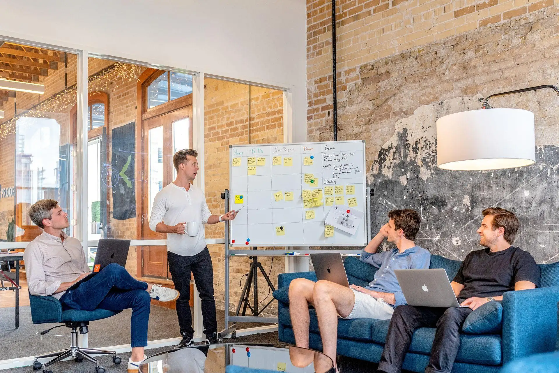 Team-Besprechung vor einem Whiteboard in einem Loft-Büro
